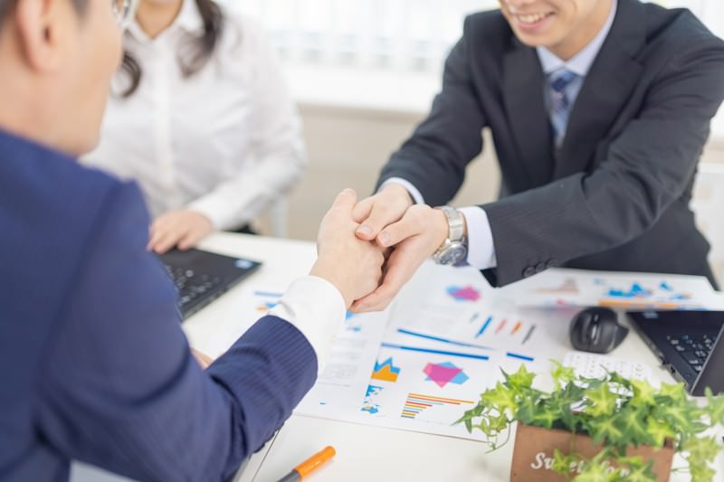商談が決まり握手をする男性
